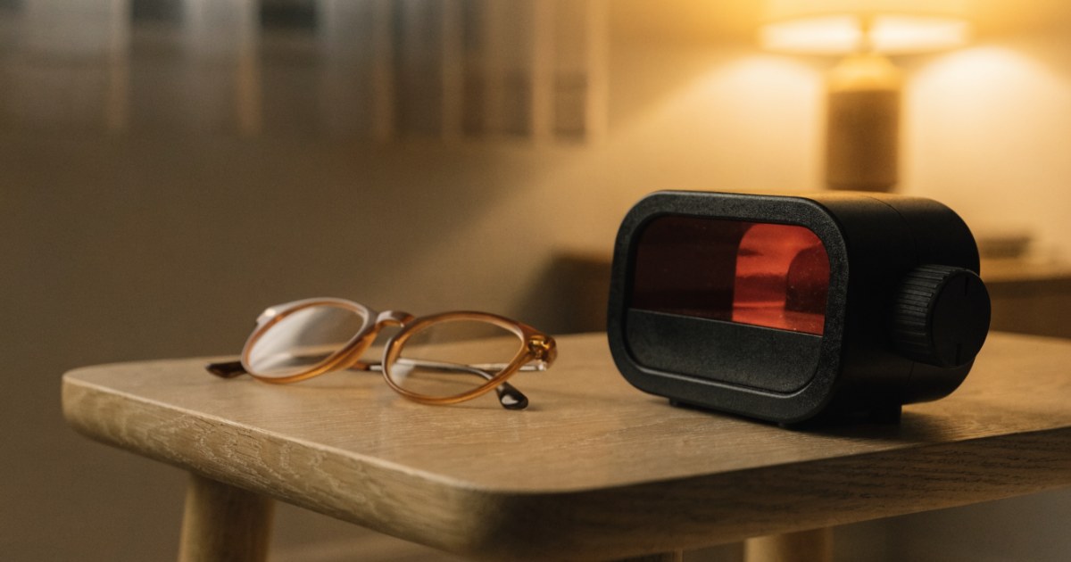 Lichtblock Erfahrungen: Rotlichtlampe und BlueBlocker-Brille auf hellem Holztisch im warmen Abendlicht